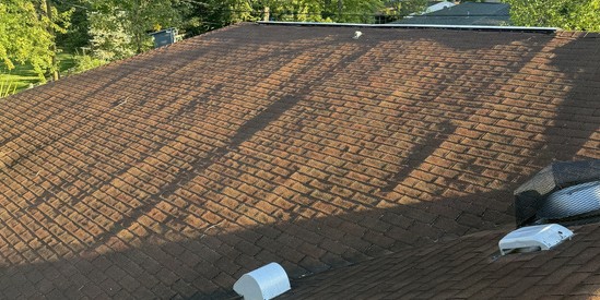 Aging roof with heavy granule loss photographed before tear-off