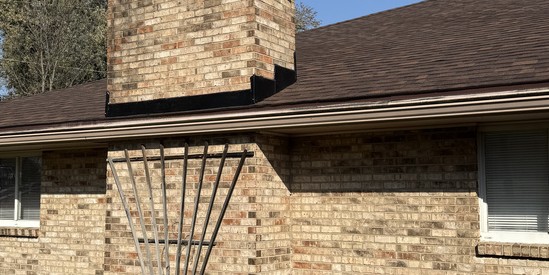 Completed chimney flashing and shingle line on a brick home