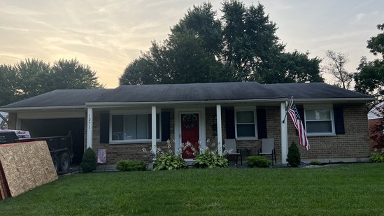 Brick ranch home with new roof photographed from the curb at sunset