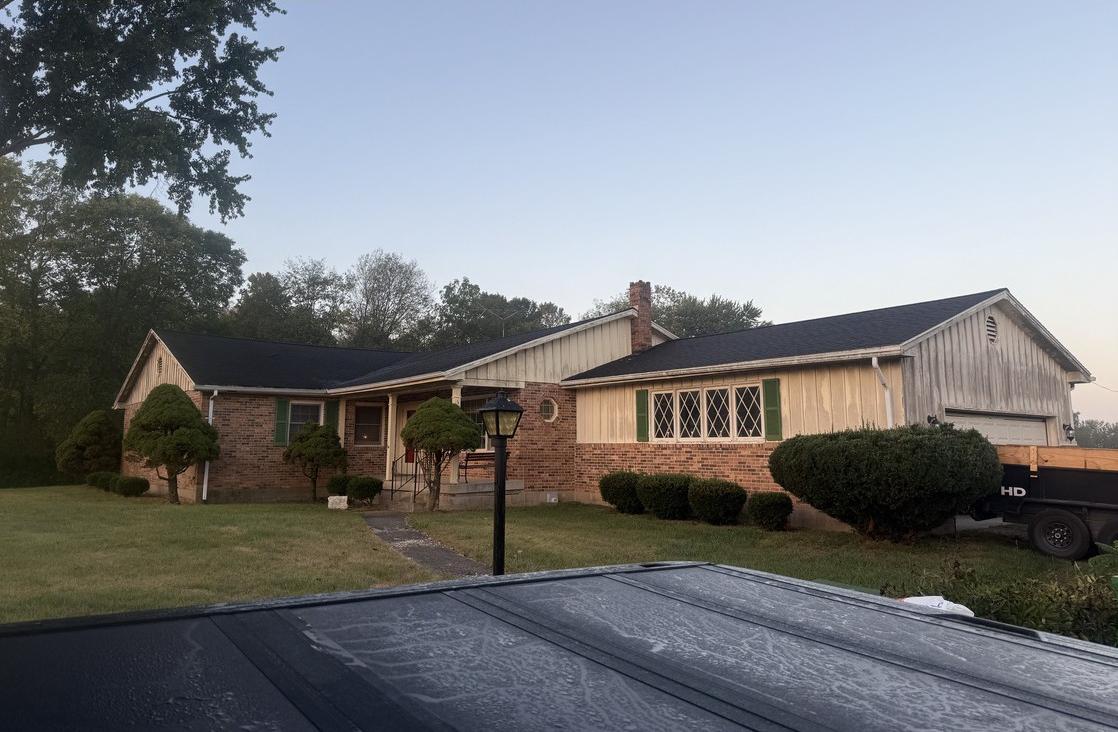 Brick country ranch home at dusk with a completed roof replacement