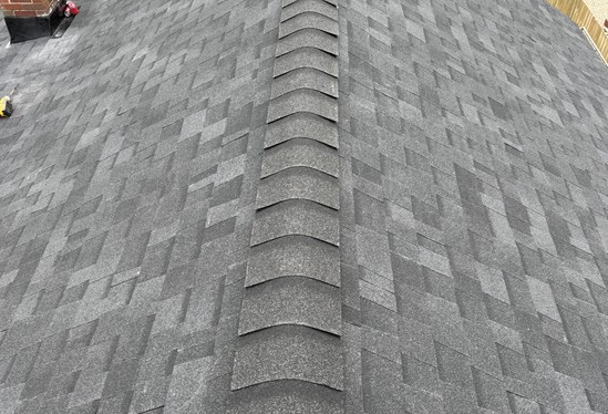 Close-up of ridge cap shingles running along a new roof ridge