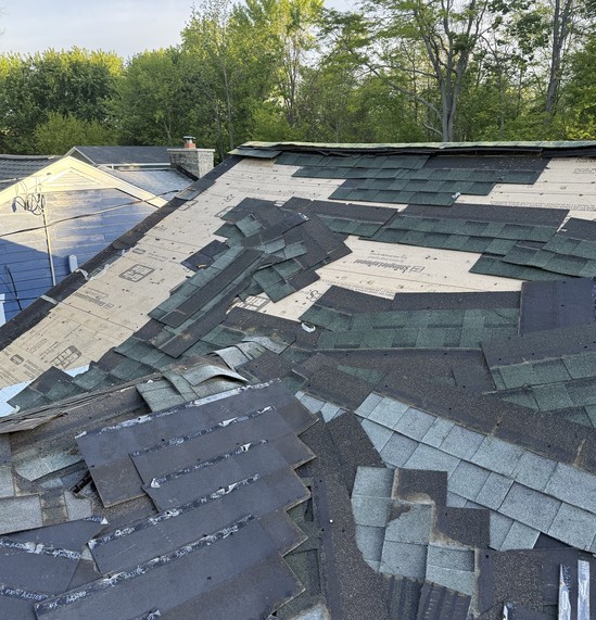 Old three-tab shingles torn loose during a roof tear-off