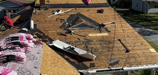 Roof mid tear-off with old shingles stripped to the decking